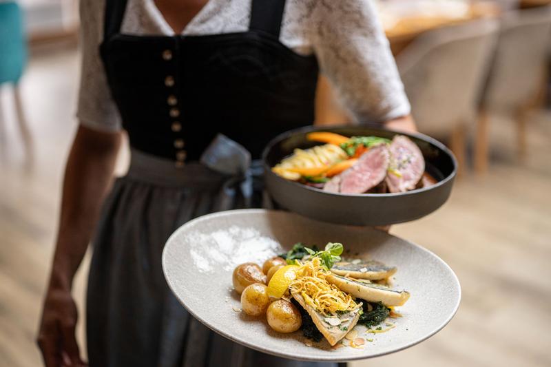 Eine Kellnerin trägt zwei Hauptgänge durch das Restaurant