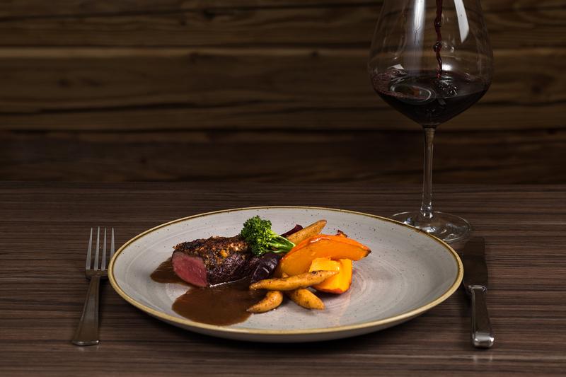 Nahaufnahme eines Gerichts mit Fleisch, Gemüse und Sauce