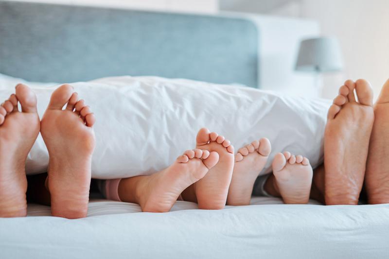 Füße einer Familie im Bett