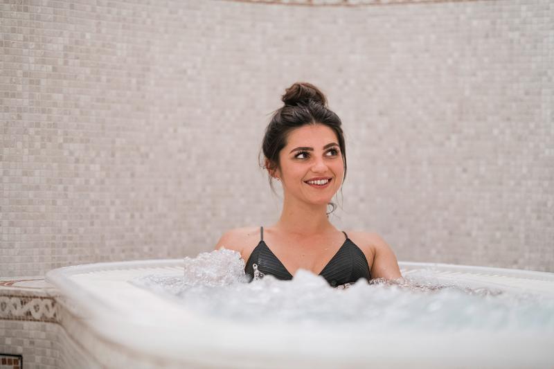 Eine Frau im Whirlpool des Hotel Berwangerhof