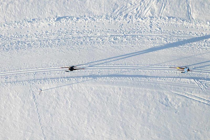 Drohnenaufnahme zweier Langläufer auf einer sonnigen Loipe