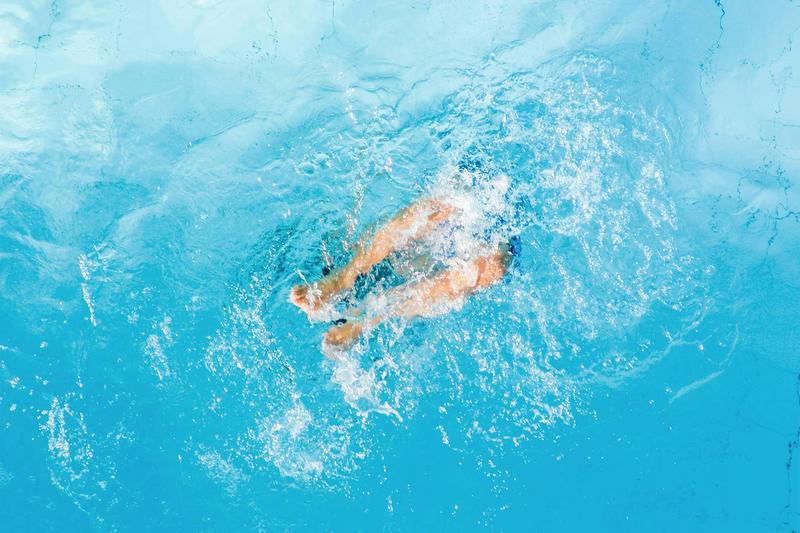 ein Kind springt in den Pool