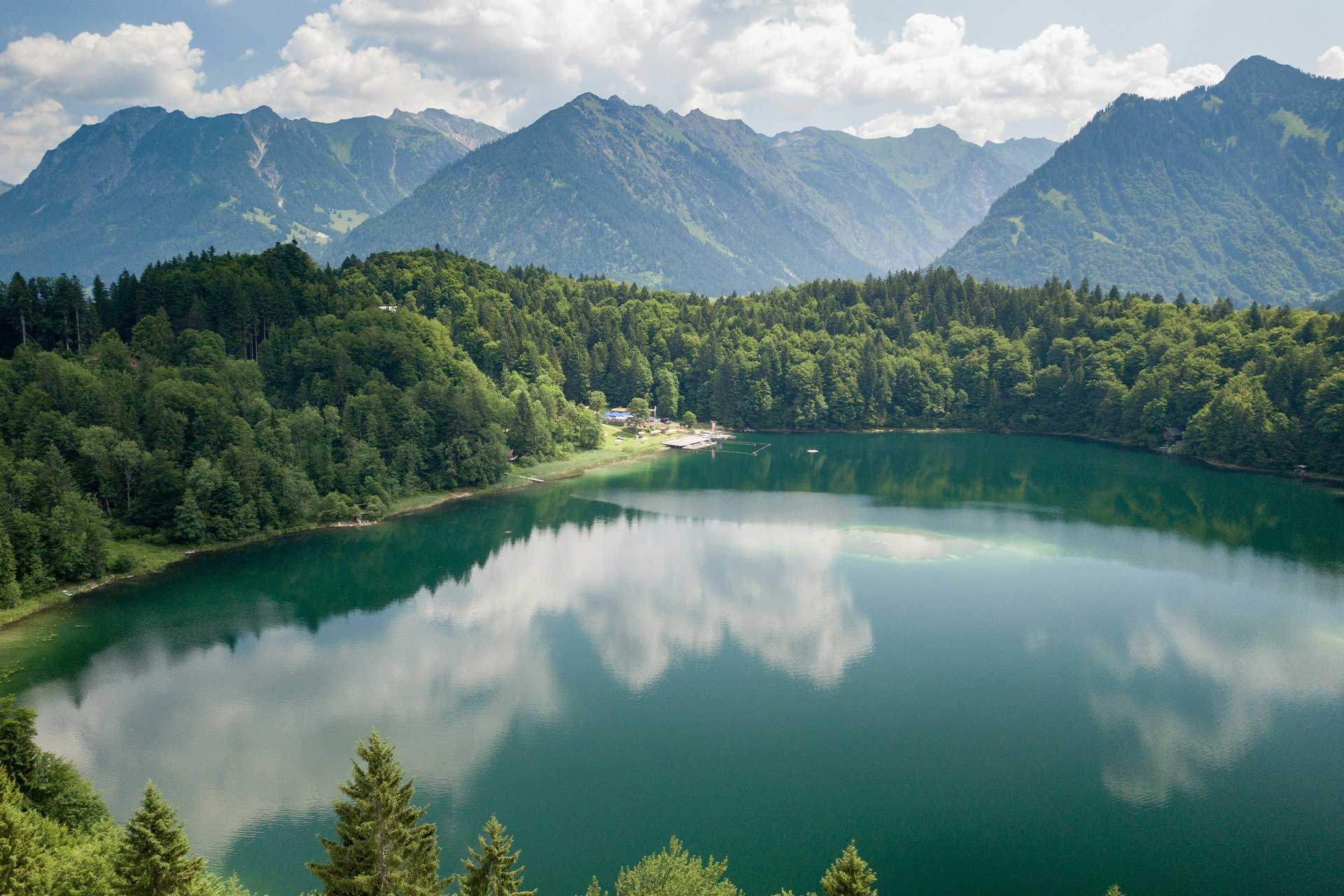 Sommerliche Bergaufnahme mit Bergsee im Vordergrund
